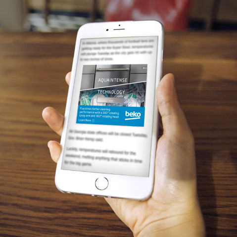 Hand holds phone with a Beko appliance ad displayed on it.