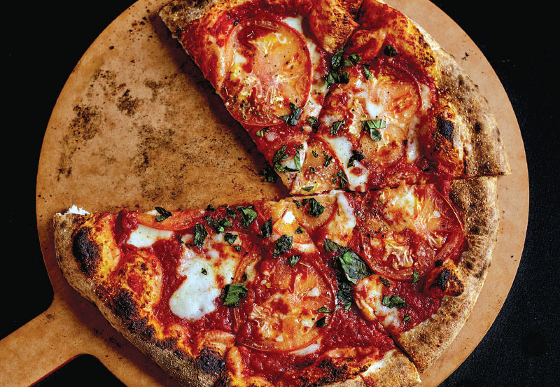 SLYCE-onePieceMissing-800x553-72ppi Pizza on peel with one piece missing