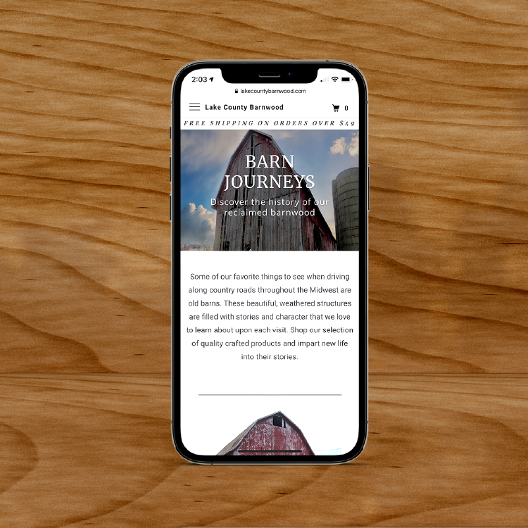 iPhone on a wooden surface, displaying Lake County Barnwood website