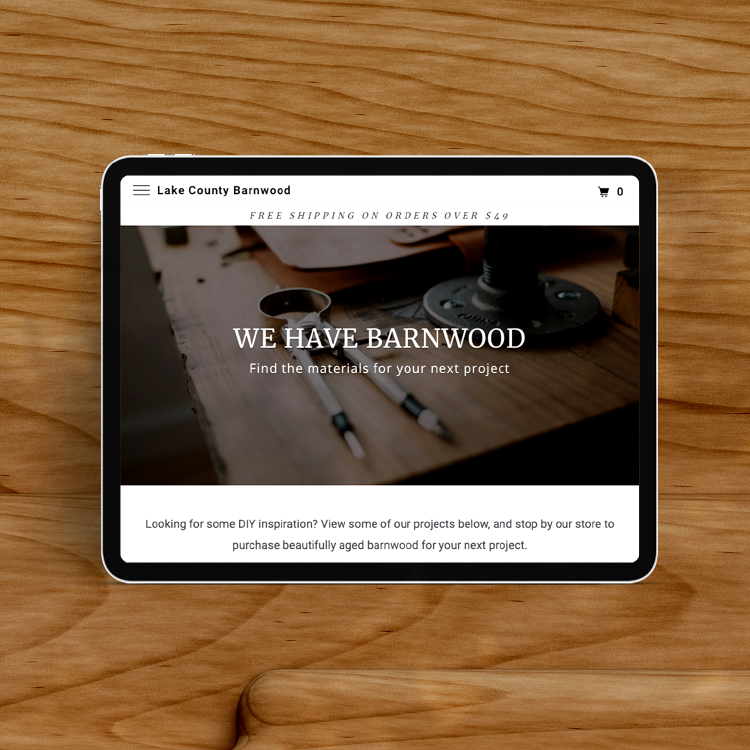 tablet on wooden surface, displaying the Lake County Barnwood website