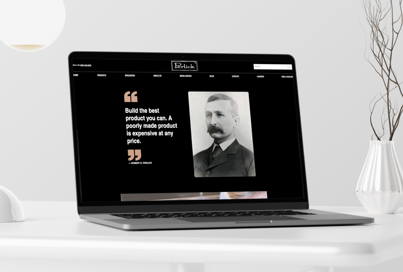 Laptop sitting on a white desk, screen shows Perlick website