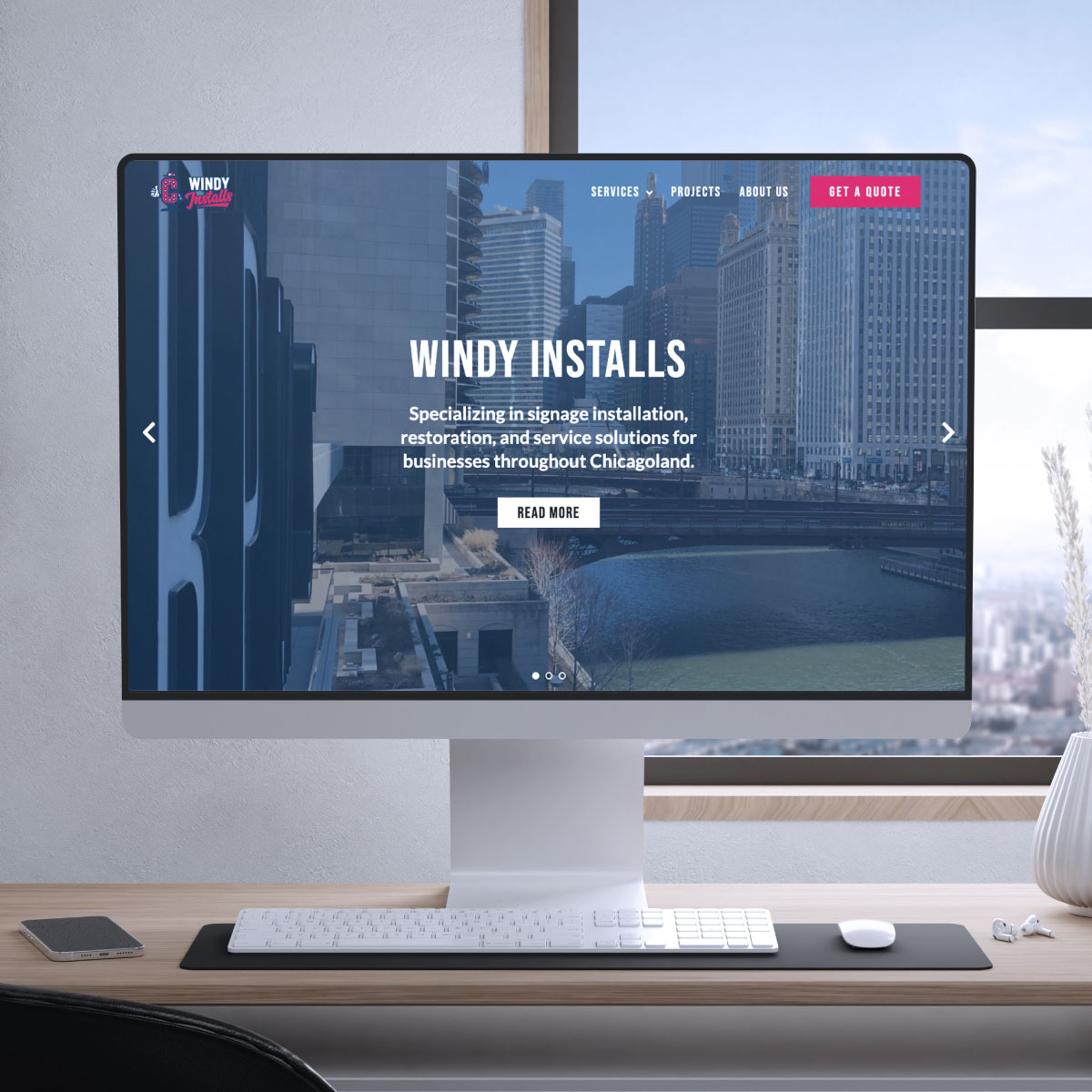 webDev-windyInstalls computer sitting on a desk, on the screen the homepage of the Windy Installs website is displayed