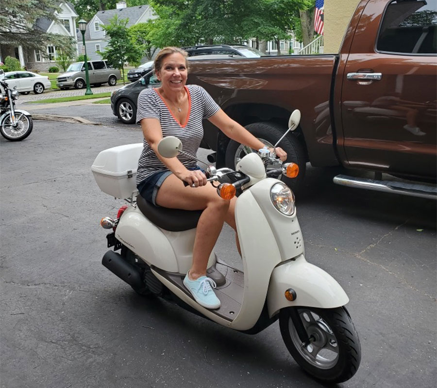 Amy smiling on a scooter