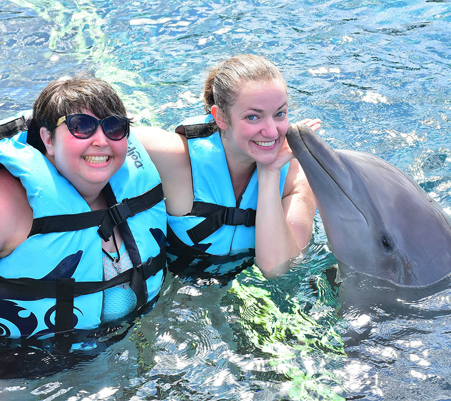 Jenna and friend swimming with dolphins