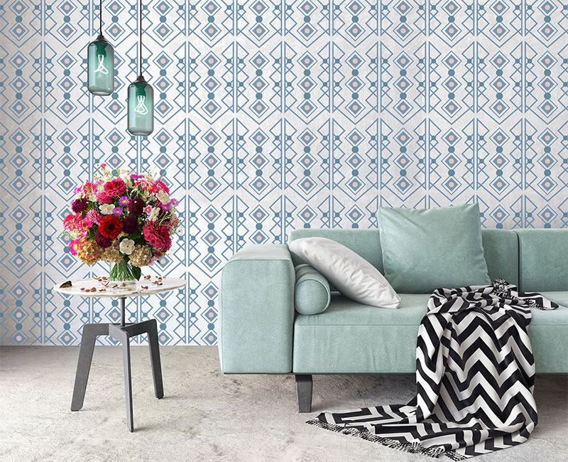 a light green couch sitting in front of custom blue pattern wallpaper