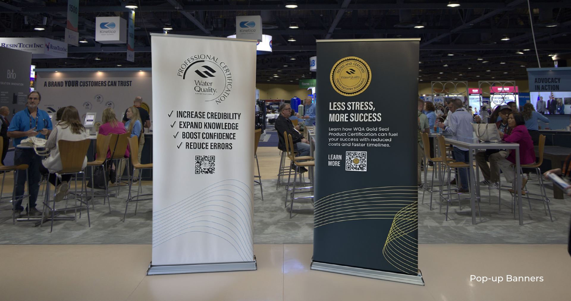 WQA-pop-up Two beautifully designed tradeshow pop-up banners sit on a crowded tradeshow floor.